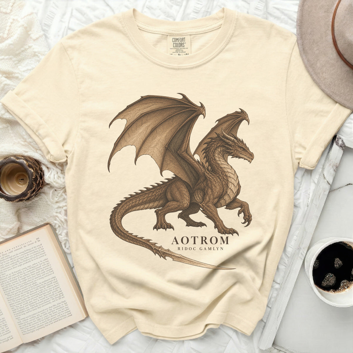 Cream t-shirt with a brown dragon graphic and text "AOTROM RIDOC GAMLYN".