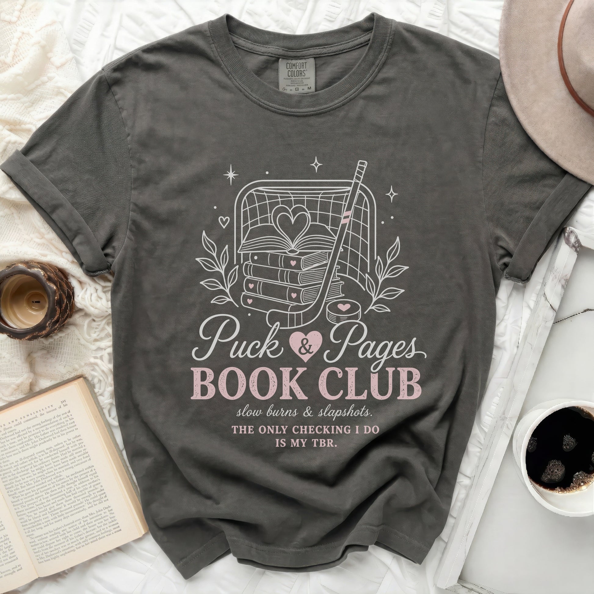 Dark gray t-shirt with "Puck & Pages Book Club" text and hockey graphics.