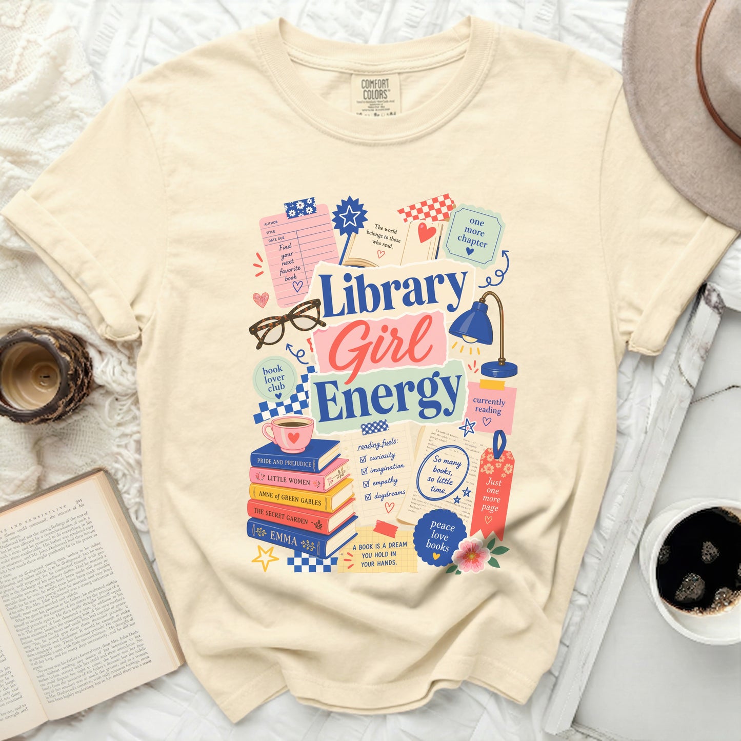 Cream t-shirt with "Library Girl Energy" graphic and book-themed illustrations.