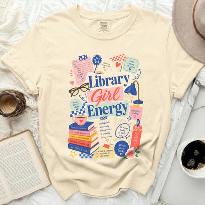Cream t-shirt with "Library Girl Energy" graphic and book-themed illustrations.