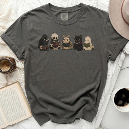 Dark grey t-shirt with a graphic of a crow, skeleton, moth, cat, and ghost reading books.