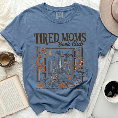 Blue t-shirt with "Tired Moms Book Club" design showing a city view.