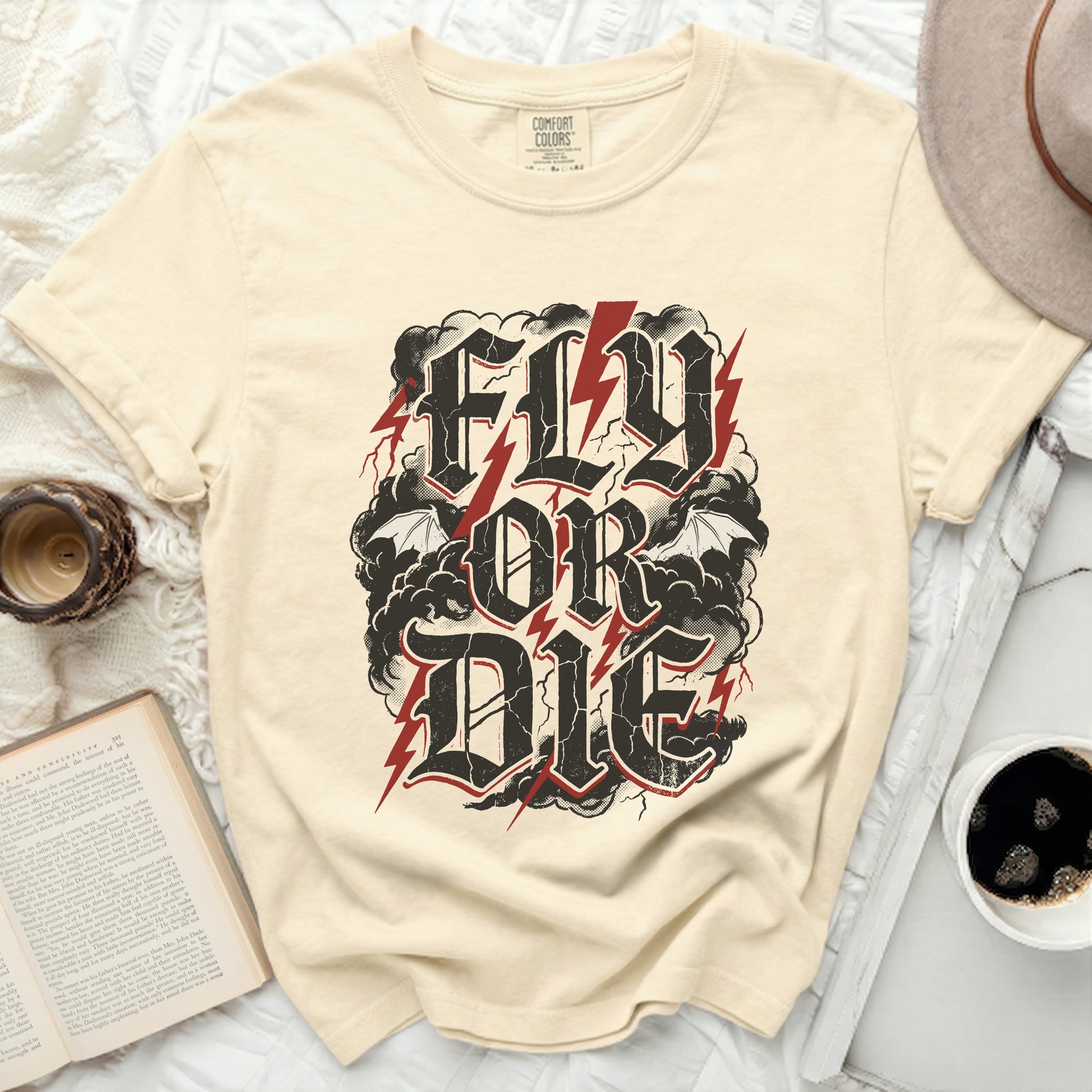 Cream t-shirt with "Fly or Die" text in distressed black font with red lightning.