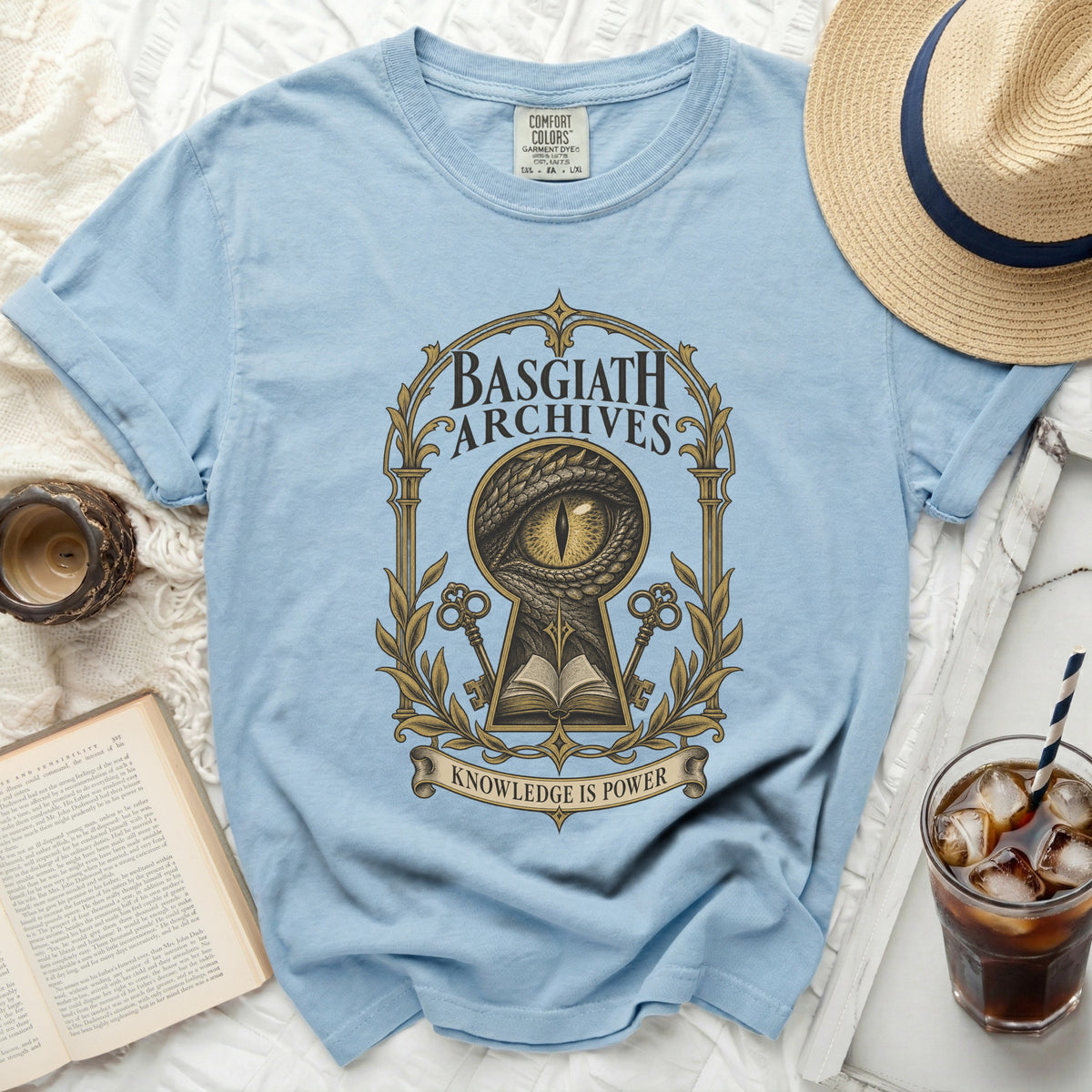 Light blue t-shirt with Basgiath Archives dragon eye keyhole design and "Knowledge is Power" text.