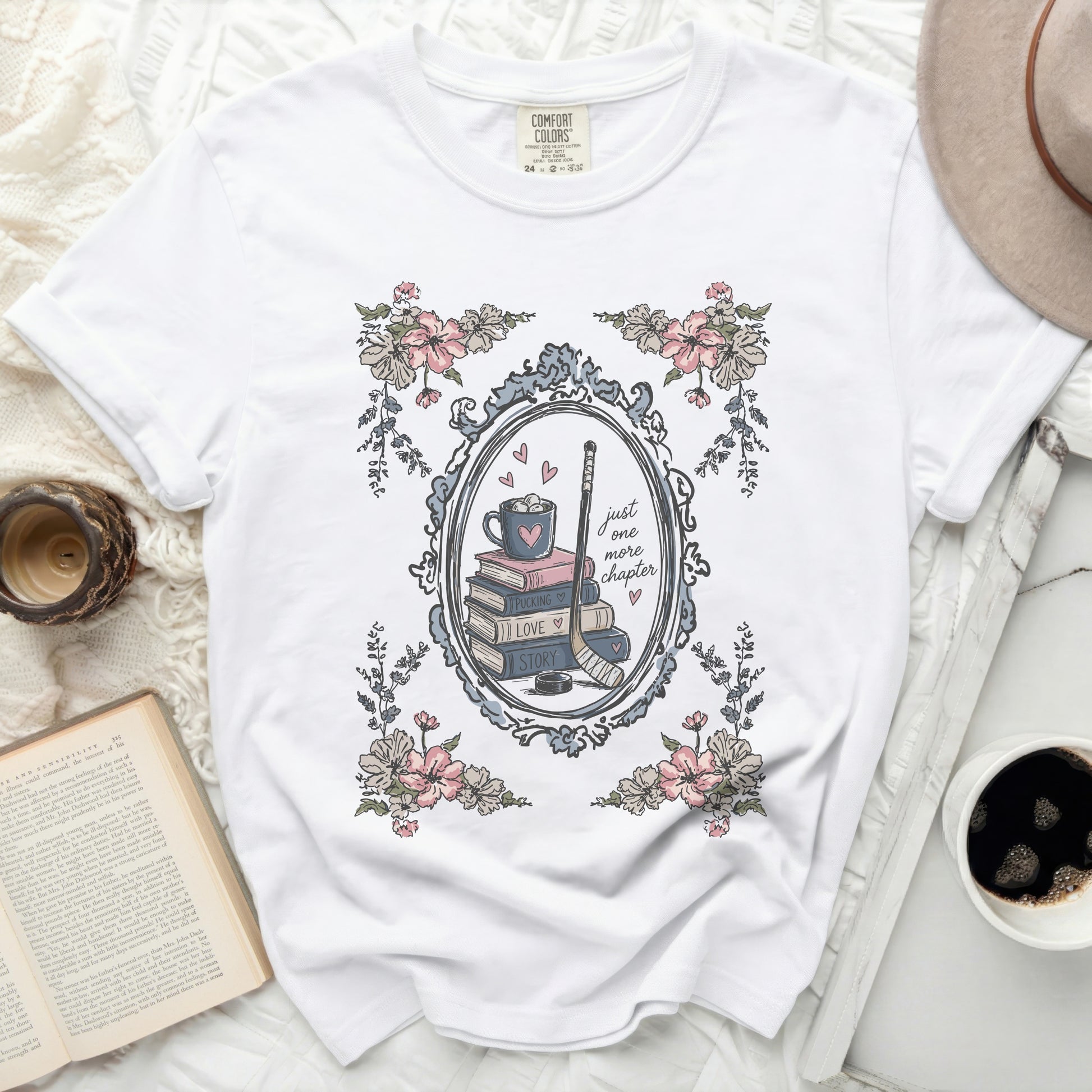 White Comfort Colors t-shirt with floral frame and "just one more chapter" book stack.