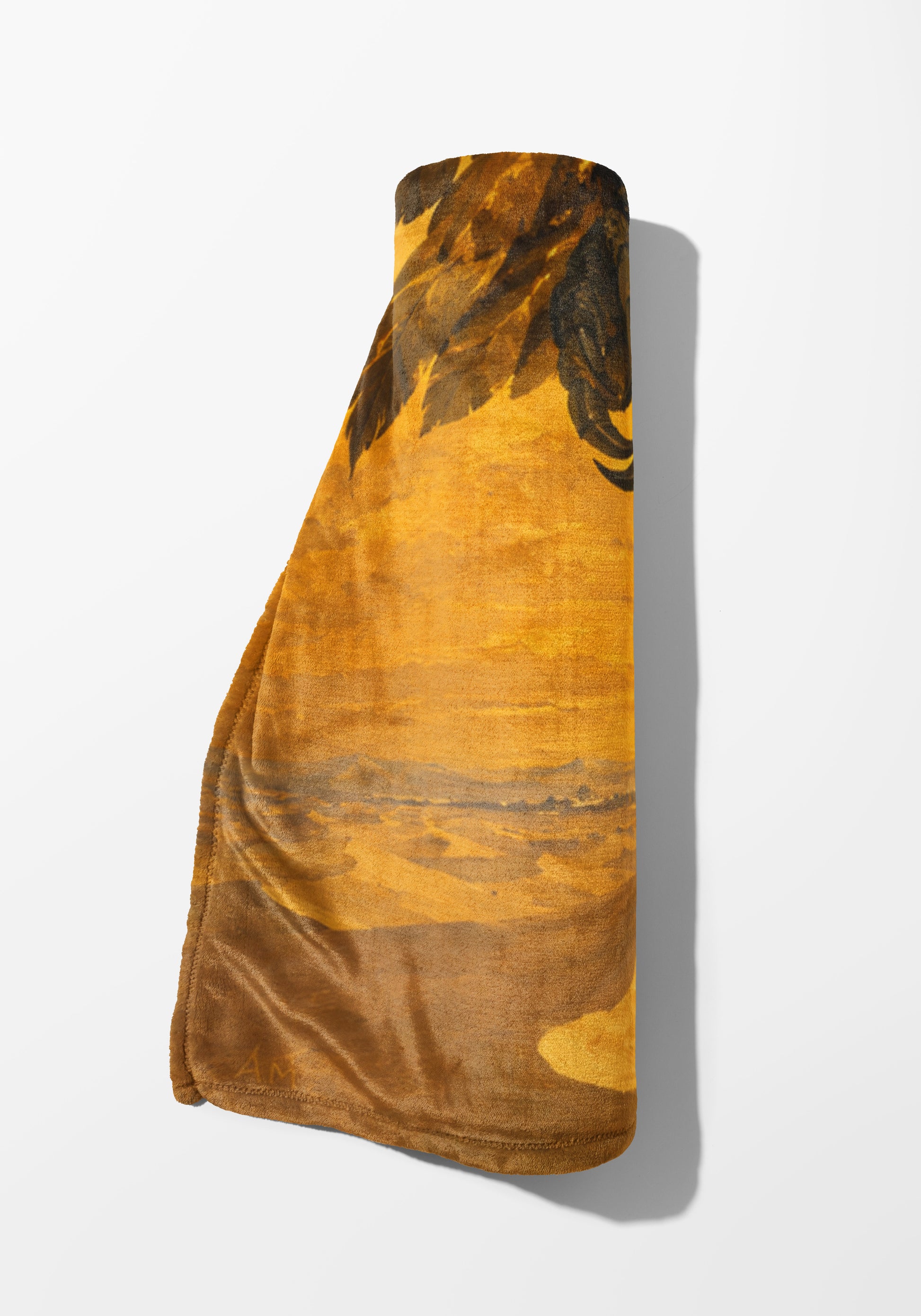 Rolled brown blanket with abstract brown and gold design and stitched edge.