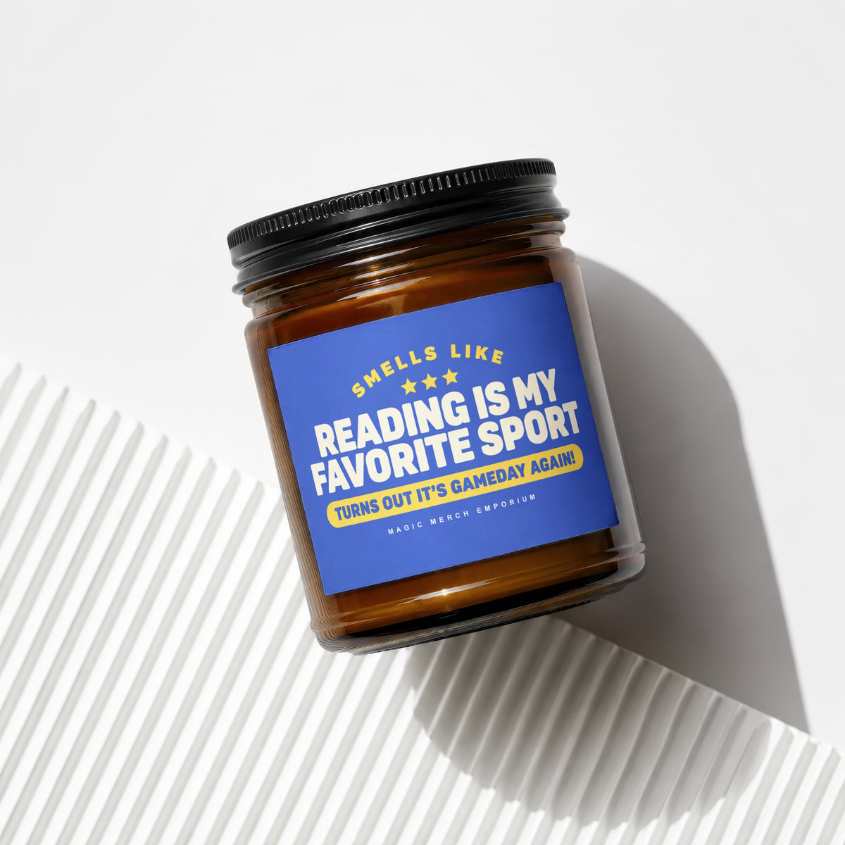 Amber candle with blue label that reads "Smells Like Reading Is My Favorite Sport".