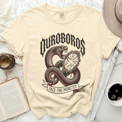 Cream t-shirt with a snake coiled around a broken mirror and text "Uroboros Face The Monster".