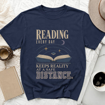 Navy t-shirt with "Reading Every Day Keeps Reality At A Safe Distance" graphic.