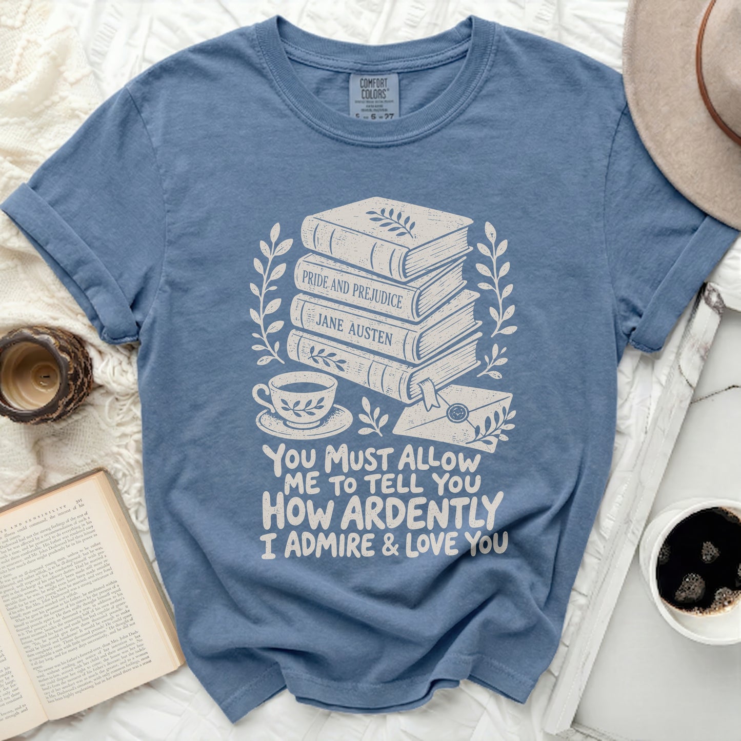 Blue t-shirt with books, teacup, letter, and Jane Austen quote.