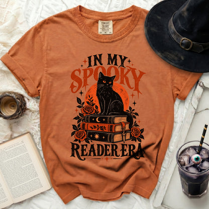 Orange t-shirt with black cat on books and "In My Spooky Reader Era" text.