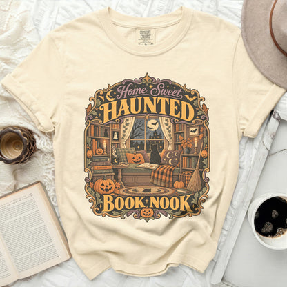 T-shirt with "Home Sweet Haunted Book Nook" graphic featuring a cozy, spooky library scene.
