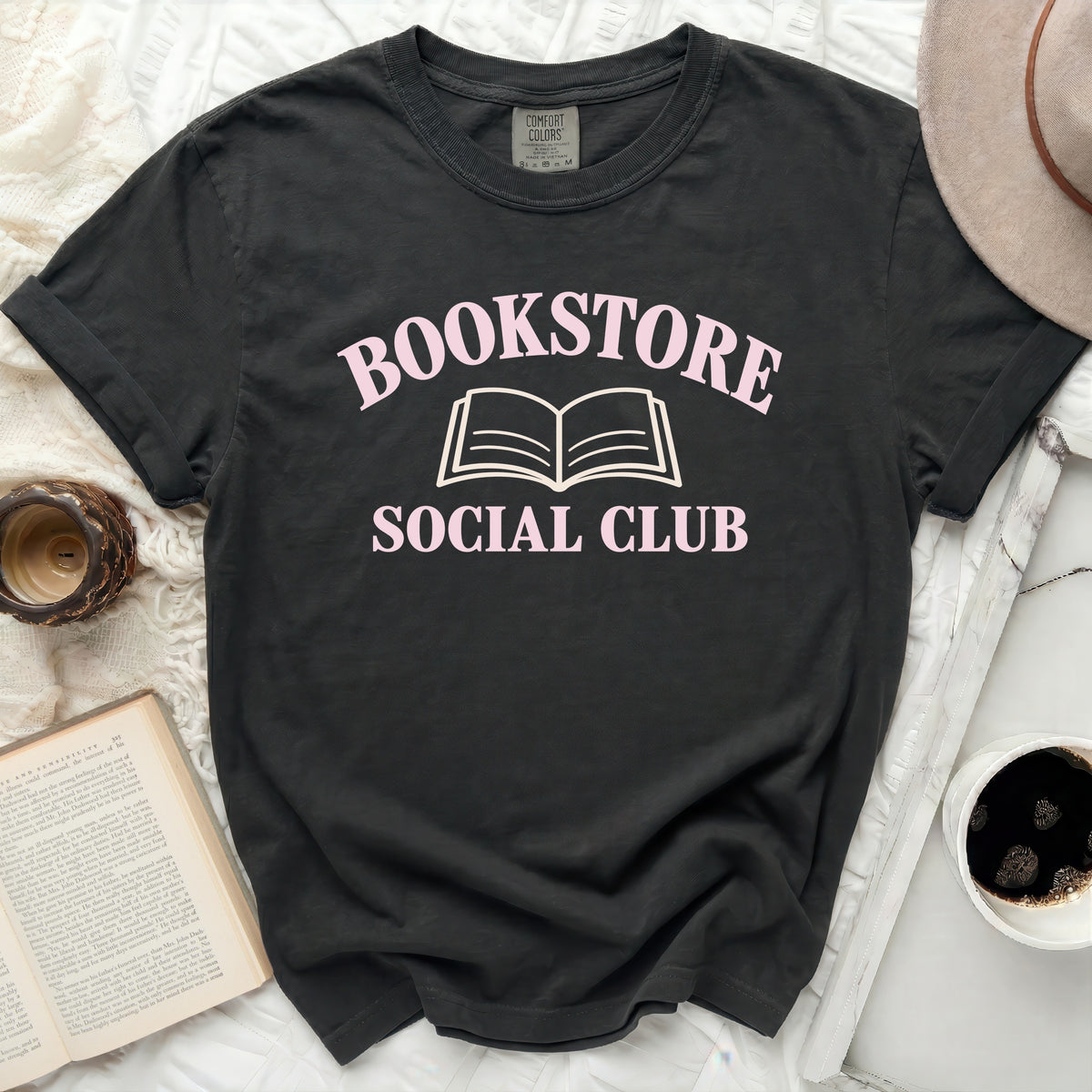 Dark grey Comfort Colors t-shirt with "Bookstore Social Club" and an open book graphic.