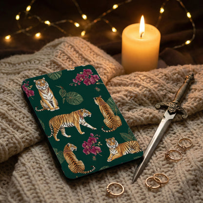 Dark green case with tigers and orchids, near candle, sword, and rings.