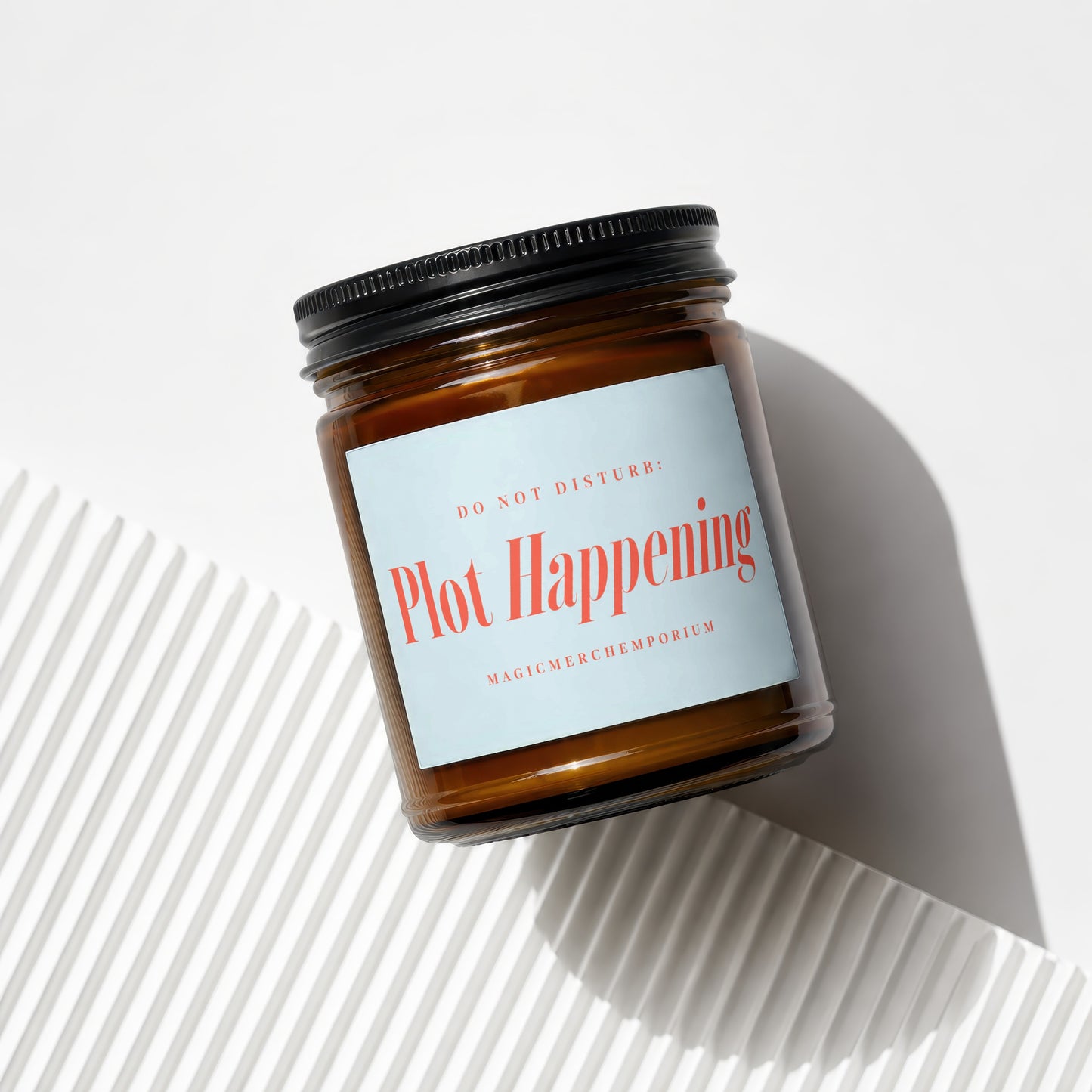 Brown glass candle with black lid, "DO NOT DISTURB: Plot Happening" label.