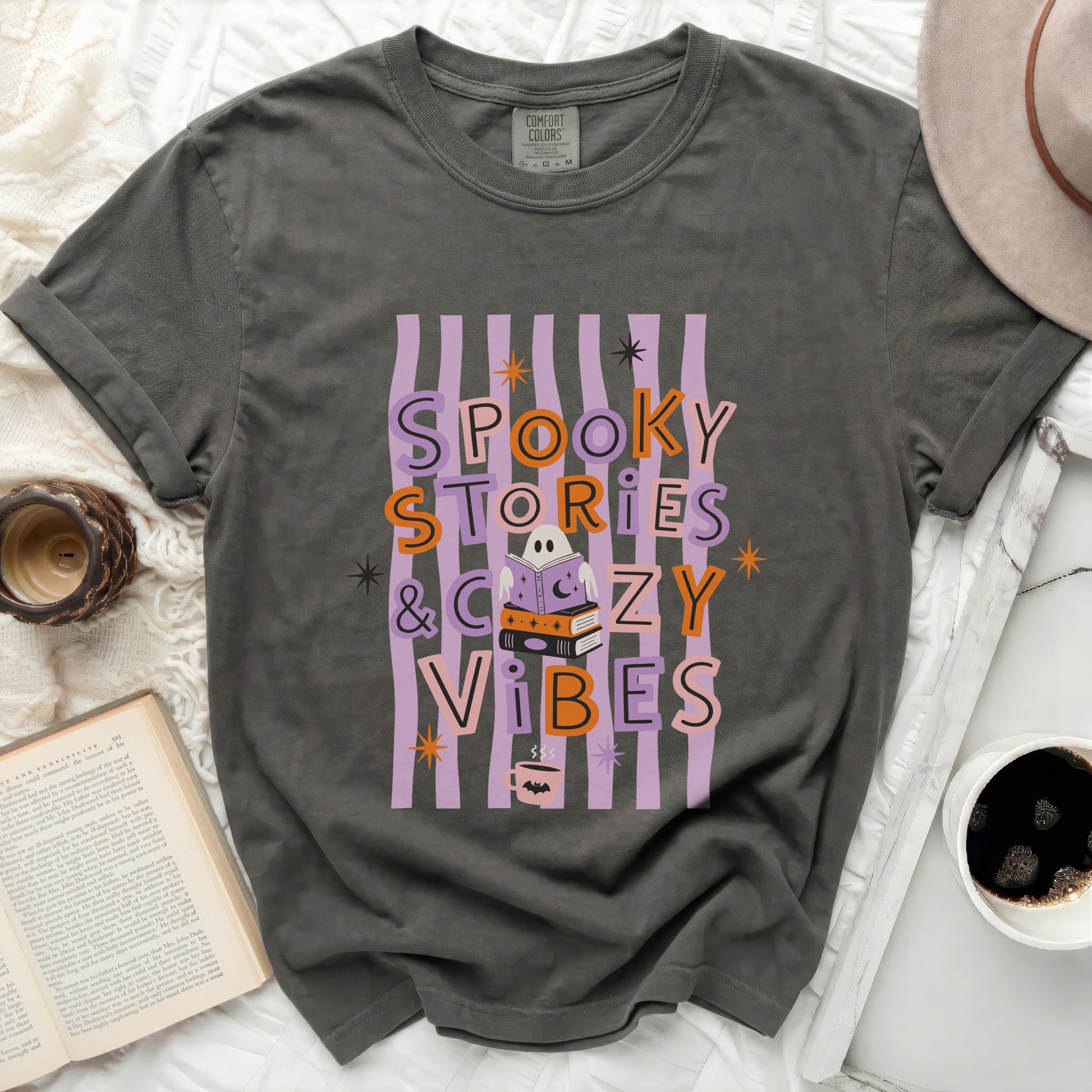 Gray "Spooky Stories & Cozy Vibes" t-shirt with Halloween graphics.