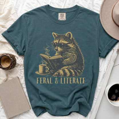 Teal t-shirt with graphic of raccoon reading book and "FERAL & LITERATE" text.