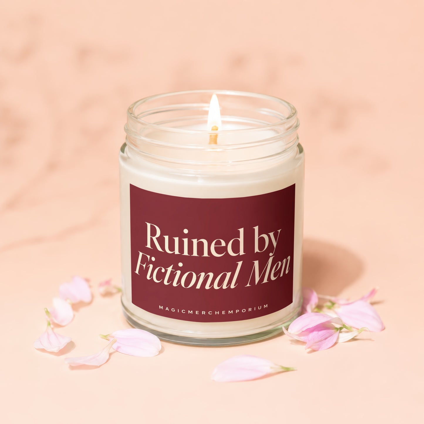 Lit candle in jar with "Ruined by Fictional Men" label, surrounded by petals.