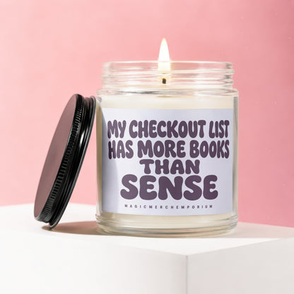 Candle with text "MY CHECKOUT LIST HAS MORE BOOKS THAN SENSE".