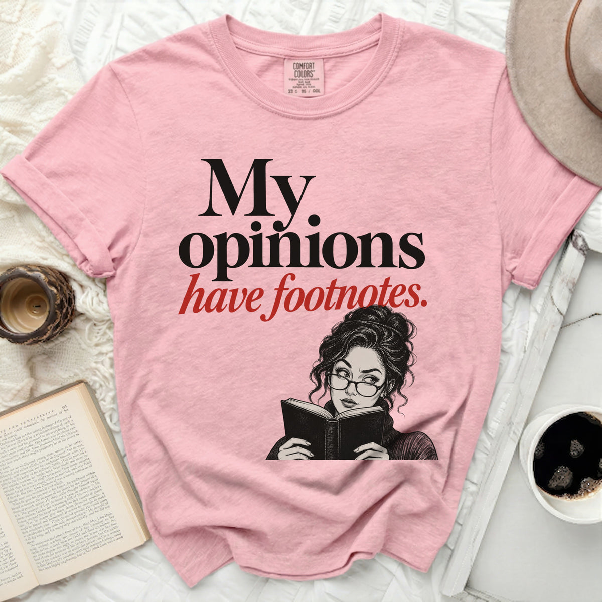 Pink t-shirt with "My opinions have footnotes" text and illustration of a woman reading.