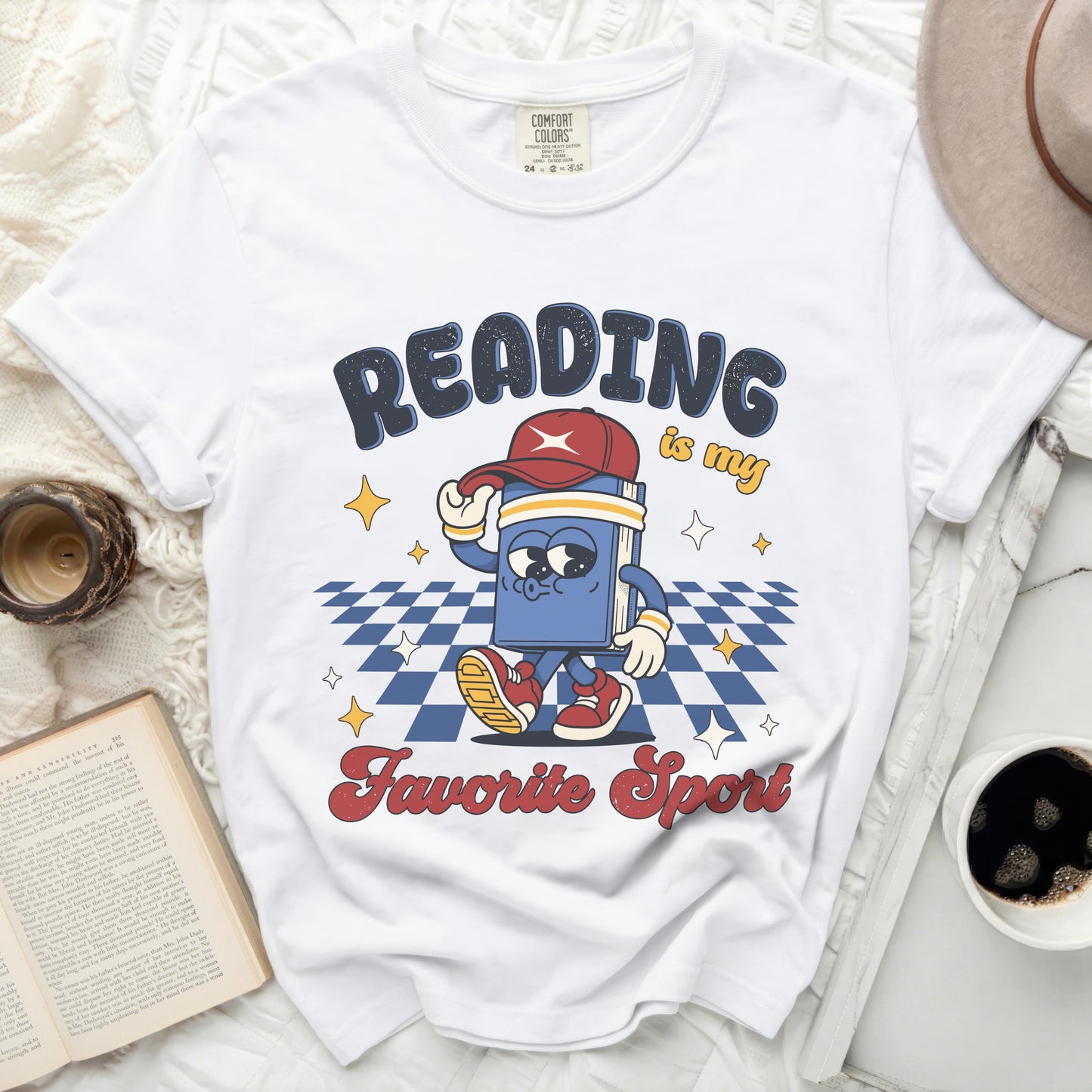 White t-shirt with "Reading is my Favorite Sport" graphic and cartoon book.