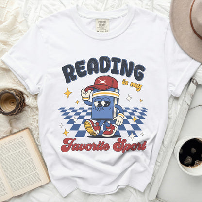 White t-shirt with "Reading is my Favorite Sport" graphic and cartoon book.