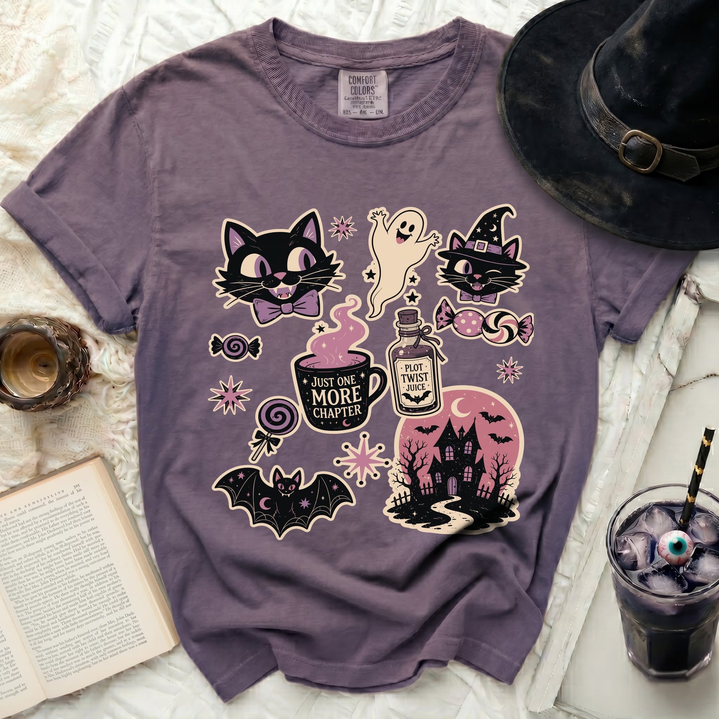 T-shirt with purple cats, ghost, bat, and Halloween themed graphics.