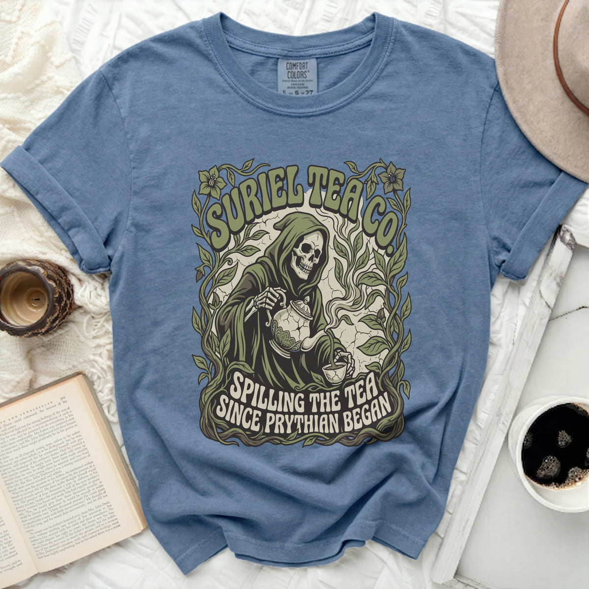 Blue t-shirt with grim reaper, "Suriel Tea Co." and "Spilling the tea since Phythian began".