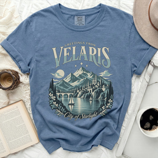 Blue t-shirt with "Greetings from Velaris City of Starlight" text and scenic artwork.