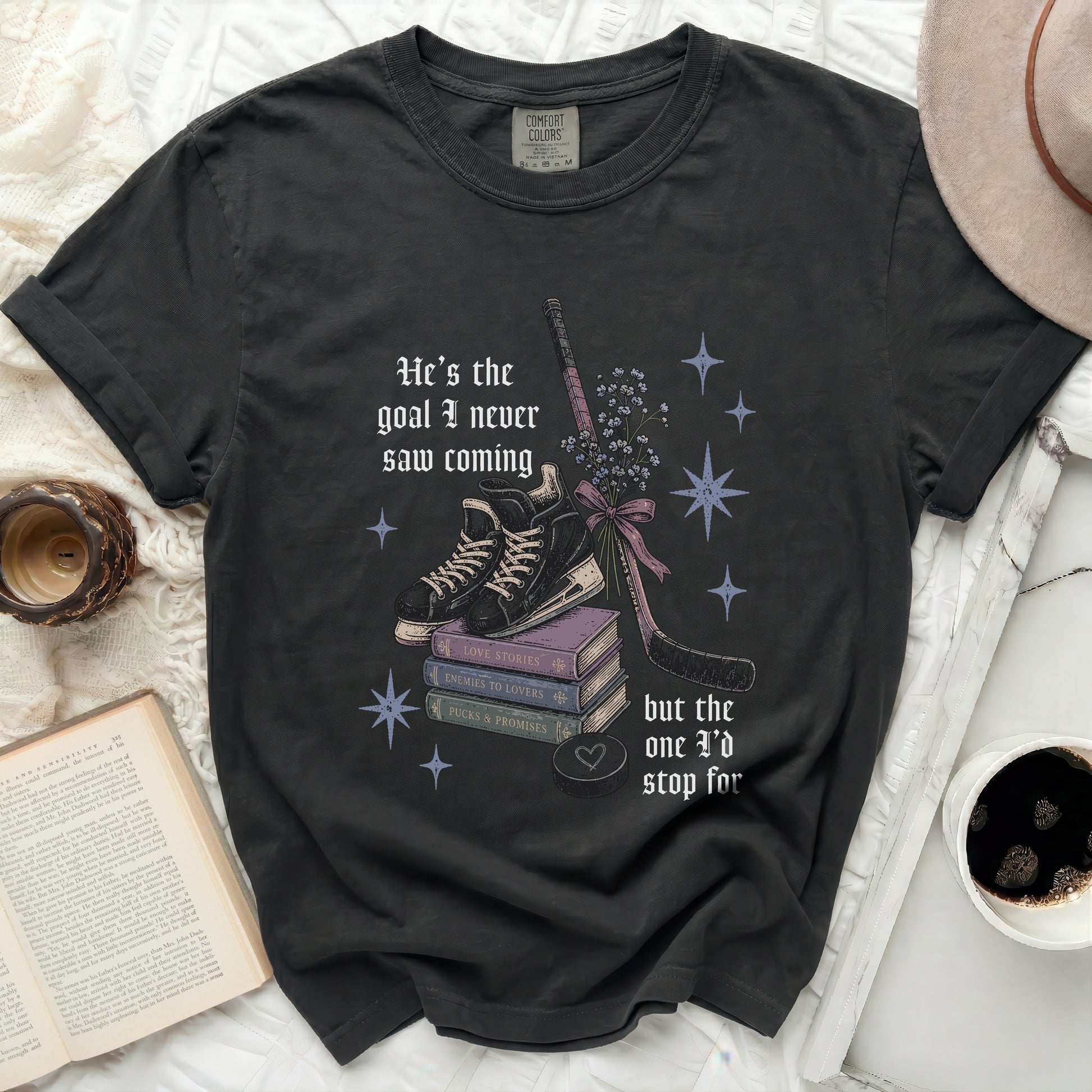 Black t-shirt with ice skates, hockey stick, and text "He's the goal I never saw coming but the one I'd stop for".