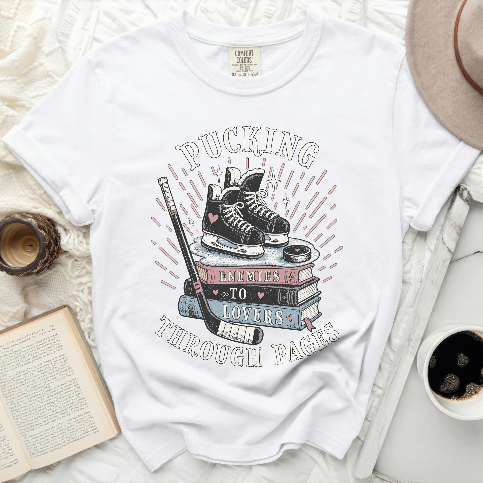 White t-shirt with "Pucking Through Pages" text, hockey skates, and books.