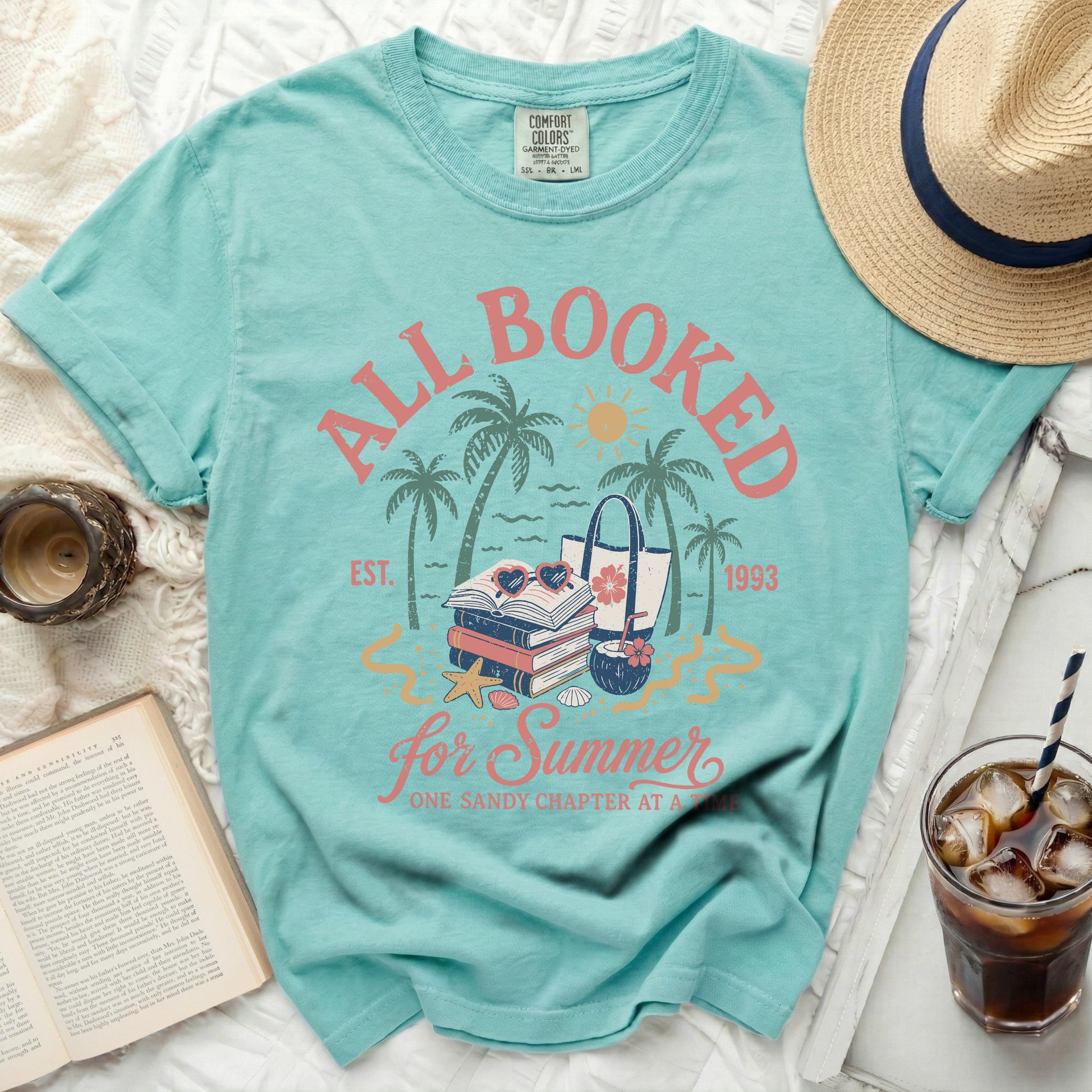 All Booked for Summer t-shirt with books, beach bag, and palm trees.