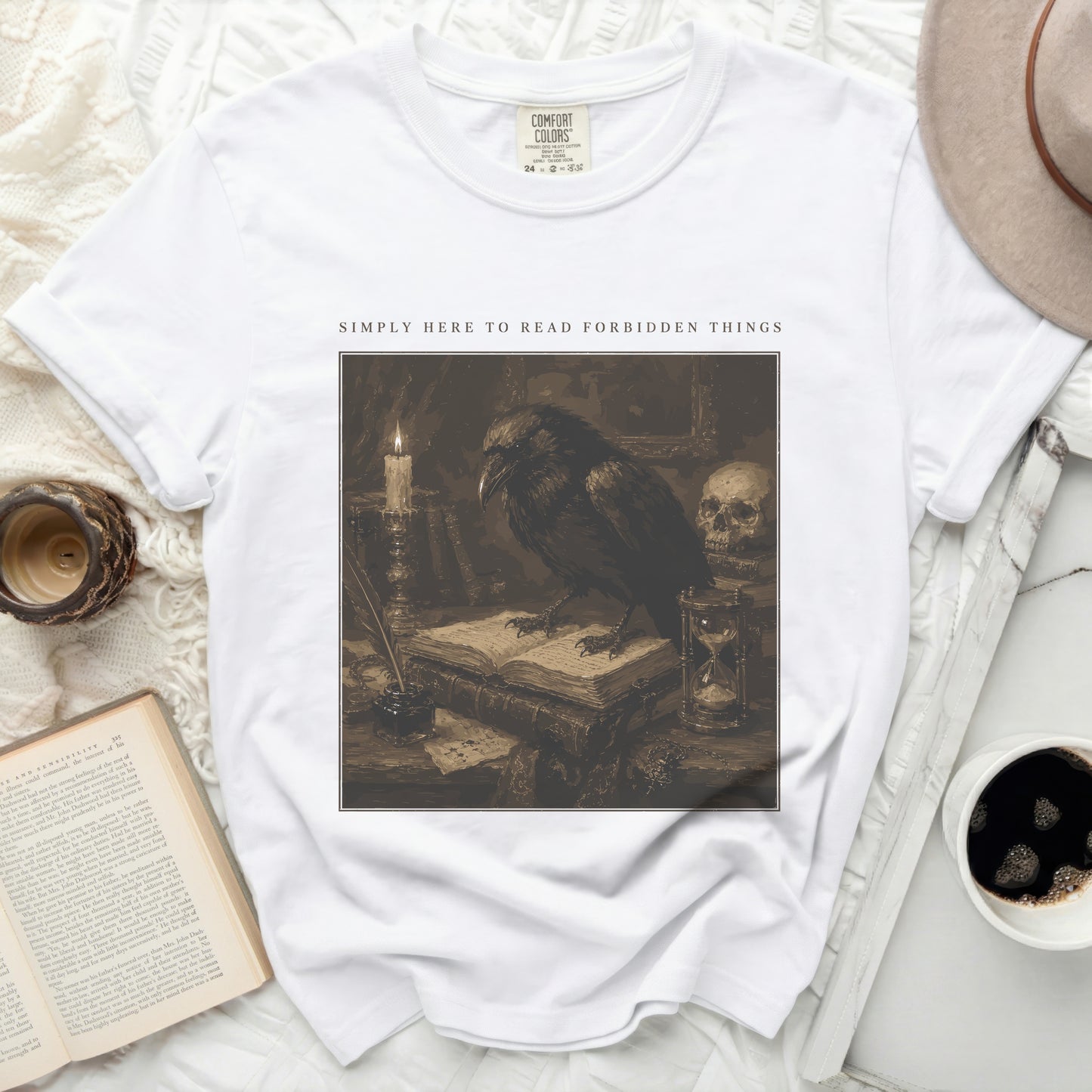 White t-shirt with "Simply Here to Read Forbidden Things" and crow illustration.