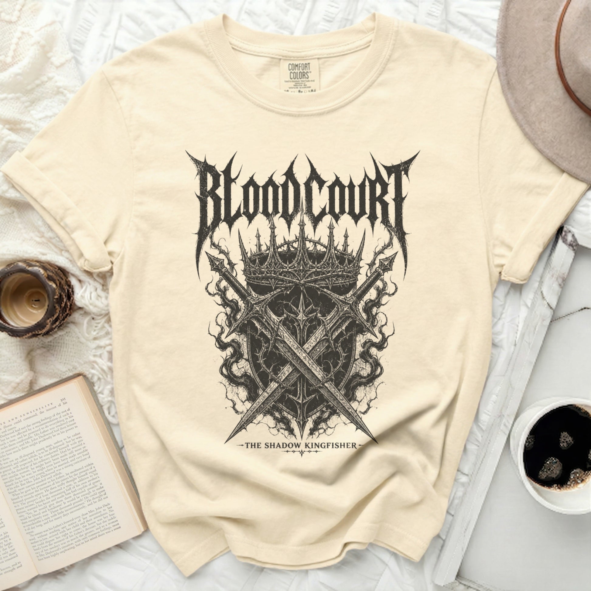 Cream t-shirt with "Blood Court The Shadow Kingfisher" band logo.