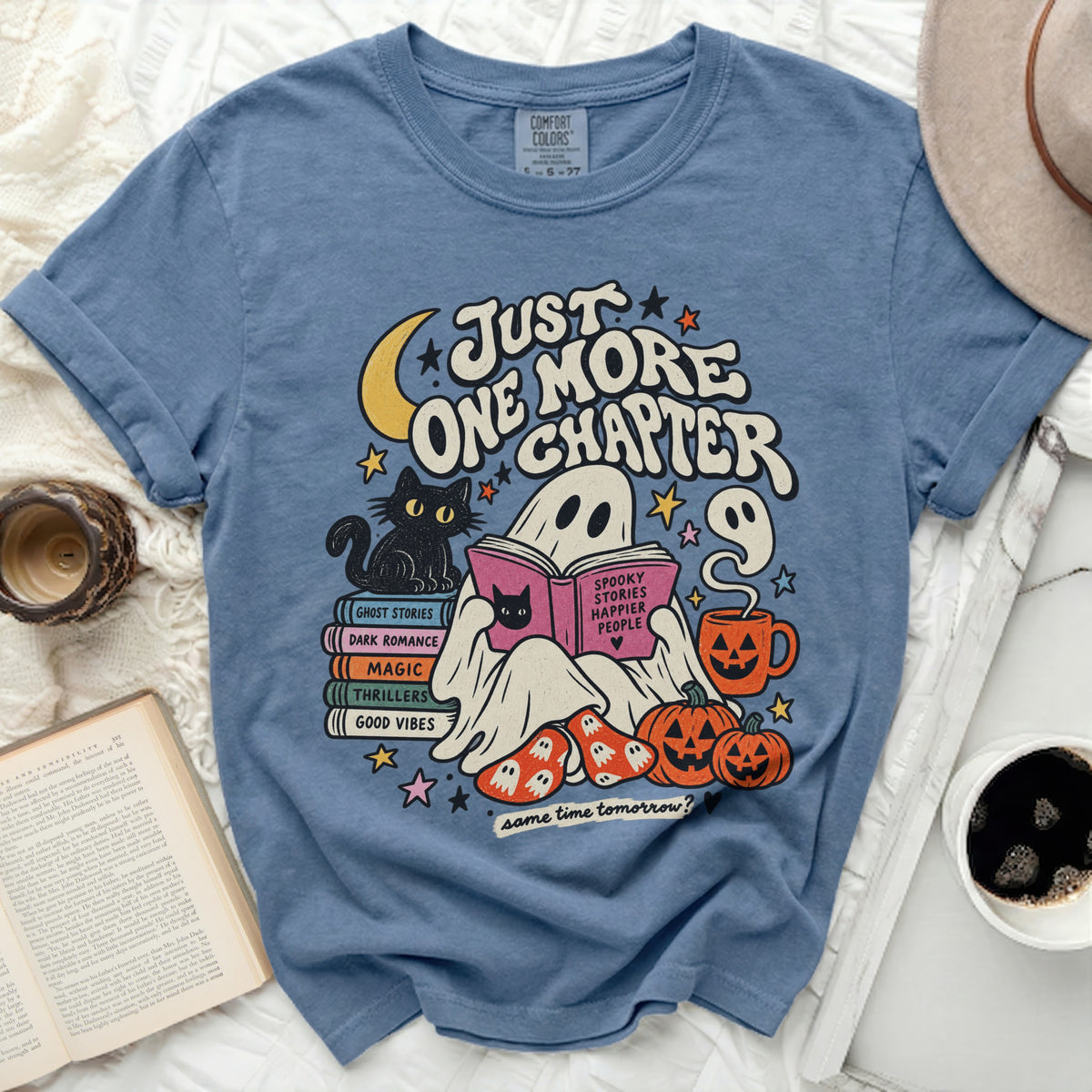 Blue t-shirt with ghost reading, cat, books, pumpkins, and "Just One More Chapter" text.