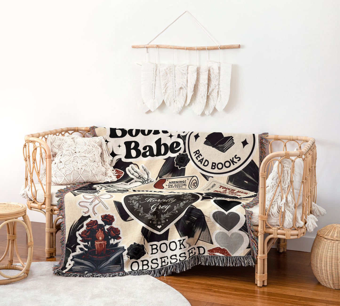 a cozy living space with a woven bench, a decorative wall hanging, and a black and white blanket with various text and illustrations.