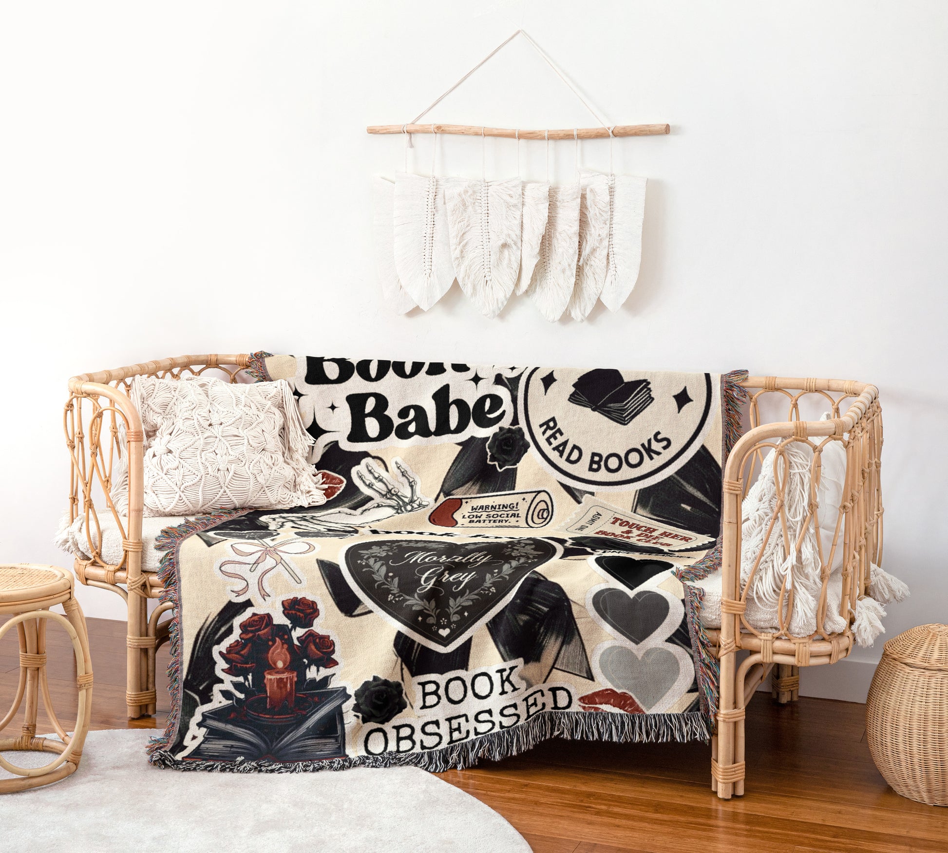 a cozy living space with a woven bench, a decorative wall hanging, and a black and white blanket with various text and illustrations.