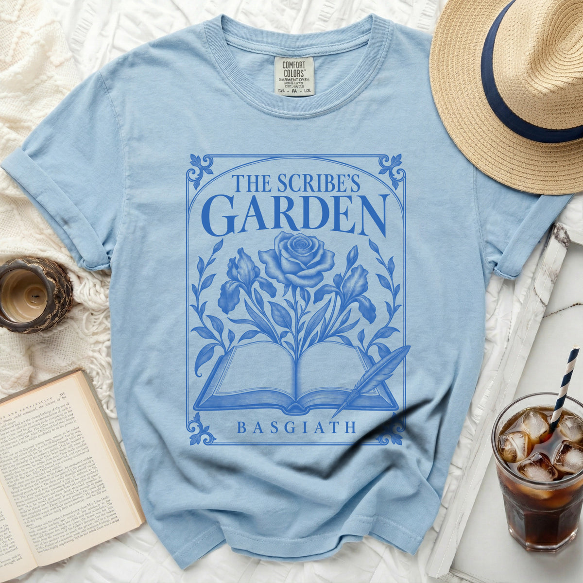Light blue t-shirt with "The Scribe's Garden" and "Basgiath" text and floral design.