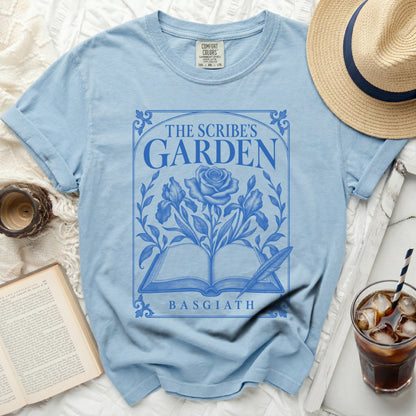 Light blue t-shirt with "The Scribe's Garden" and "Basgiath" text and floral design.