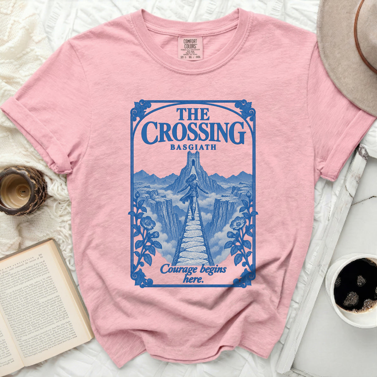 Pink t-shirt with blue graphic of "The Crossing Basgiath" and "Courage begins here."
