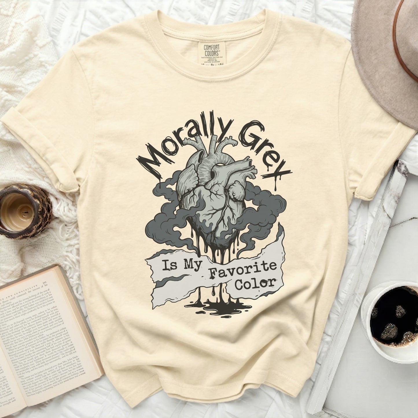 Cream t-shirt with a black ink drawing of a heart, smoke, and the text "Morally Grey Is My Favorite Color."