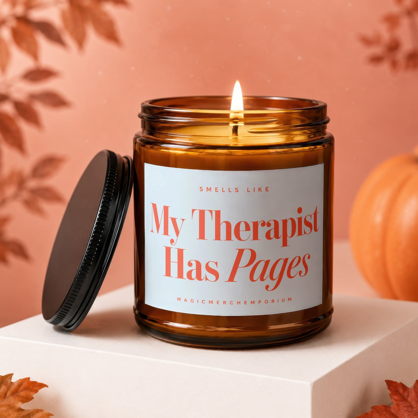 Amber jar candle with lit flame, reads "My Therapist Has Pages".