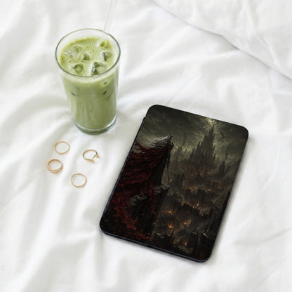 Tablet with dark fantasy art of a figure overlooking a fiery, gothic cityscape.