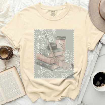 Cream t-shirt with postage stamp graphic: books, hockey stick, skates, cup, and text.