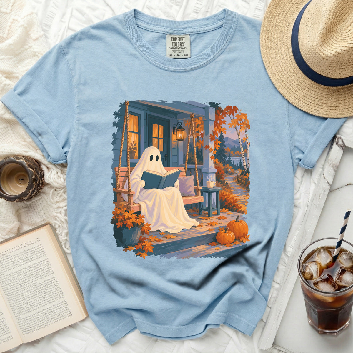 Light blue t-shirt with a ghost reading a book on a porch swing.