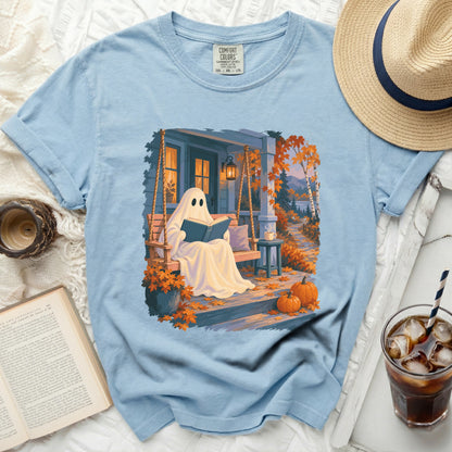 Light blue t-shirt with a ghost reading a book on a porch swing.