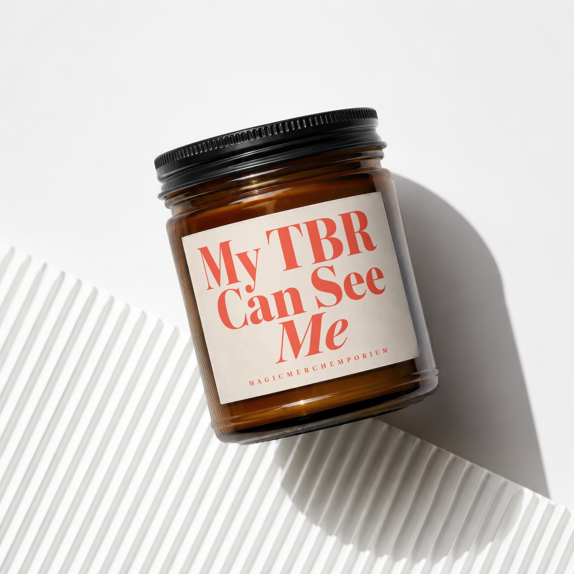 Amber glass candle with black lid reading "My TBR Can See Me".