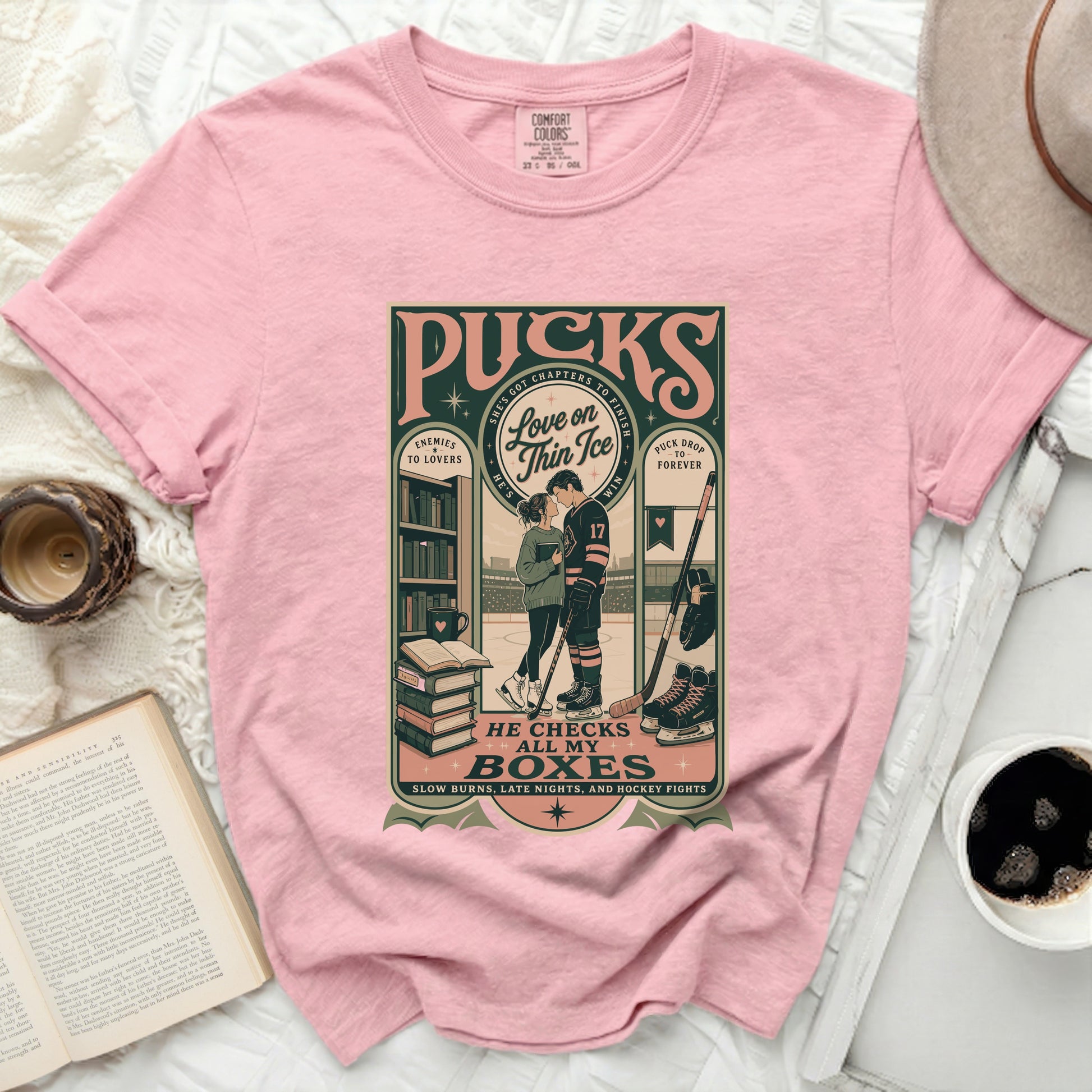 Pink t-shirt with "Pucks" graphic: Enemies to Lovers, He Checks All My Boxes.