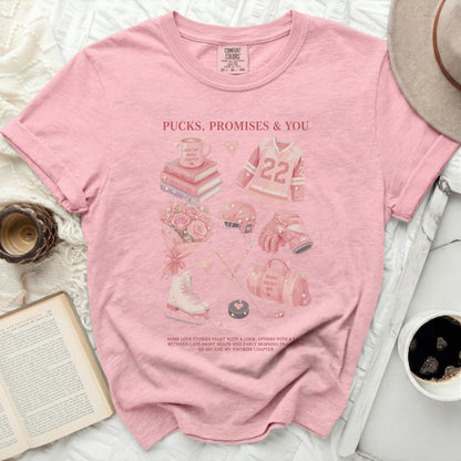 Pink t-shirt with hockey and book graphics and text.