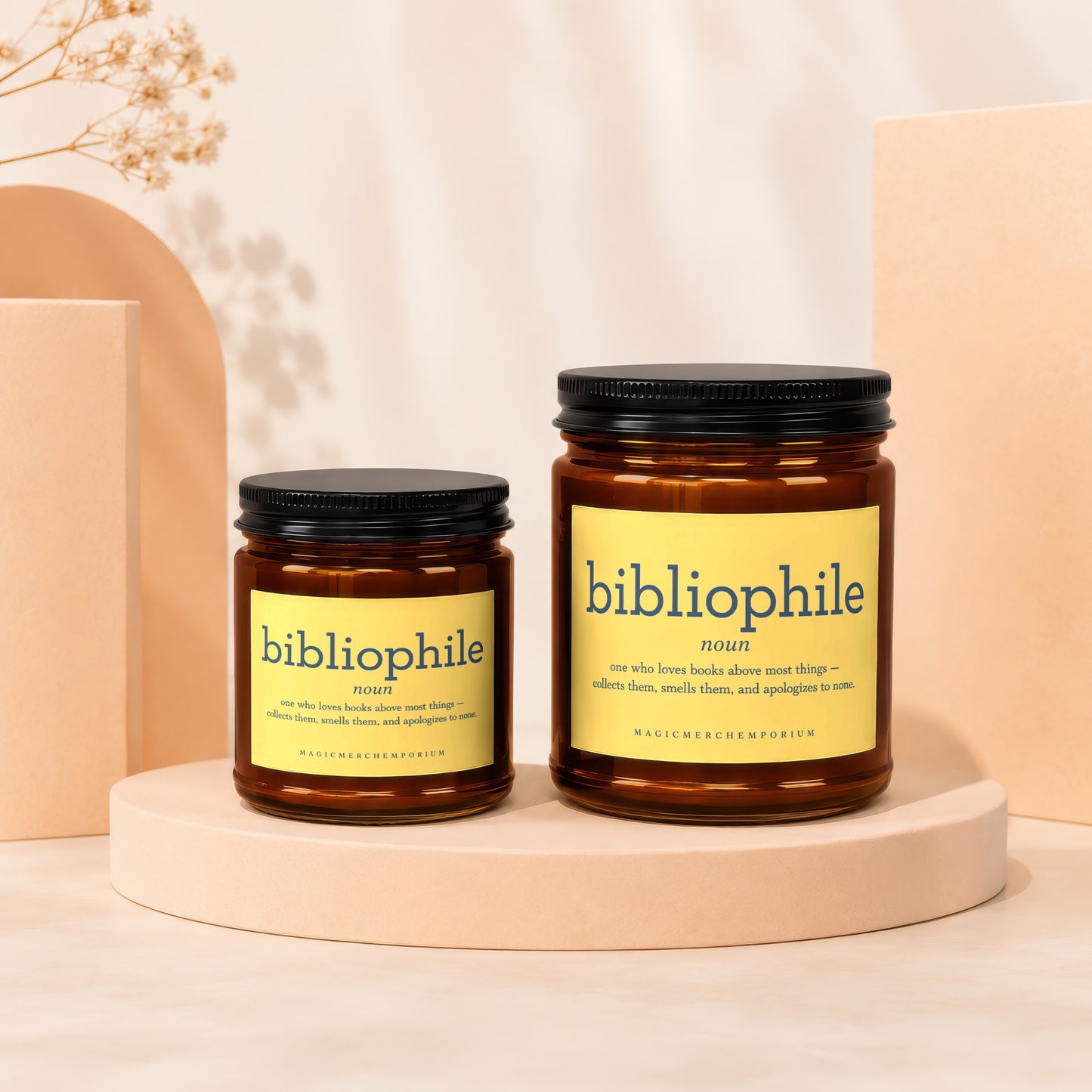 Two candles with black lids and yellow labels defining "bibliophile" definition.